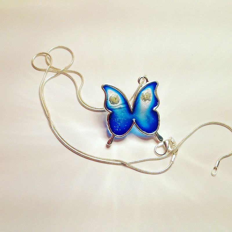 Silver necklace with pendant. Blu resin butterfly and flowers