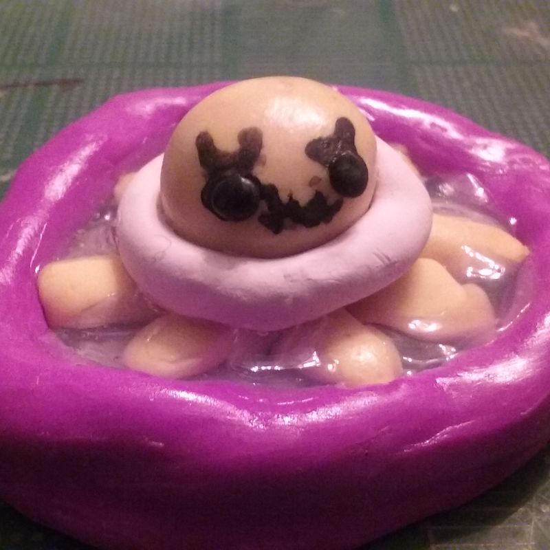 Octopus in pool with a swimming ring on polymer clay figure